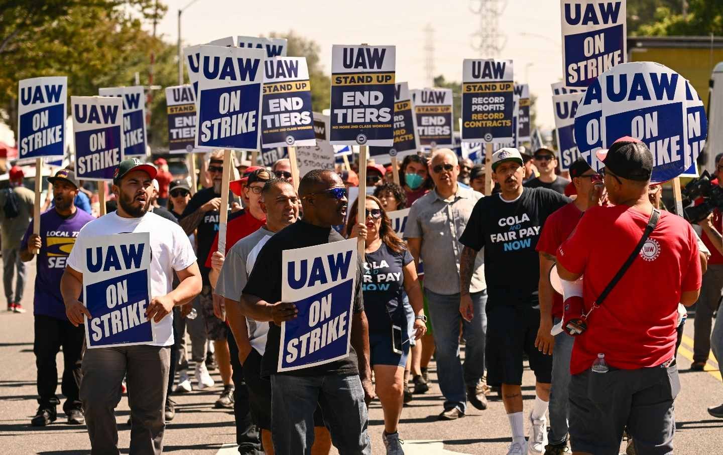 Striking UAW workers march with picket signs